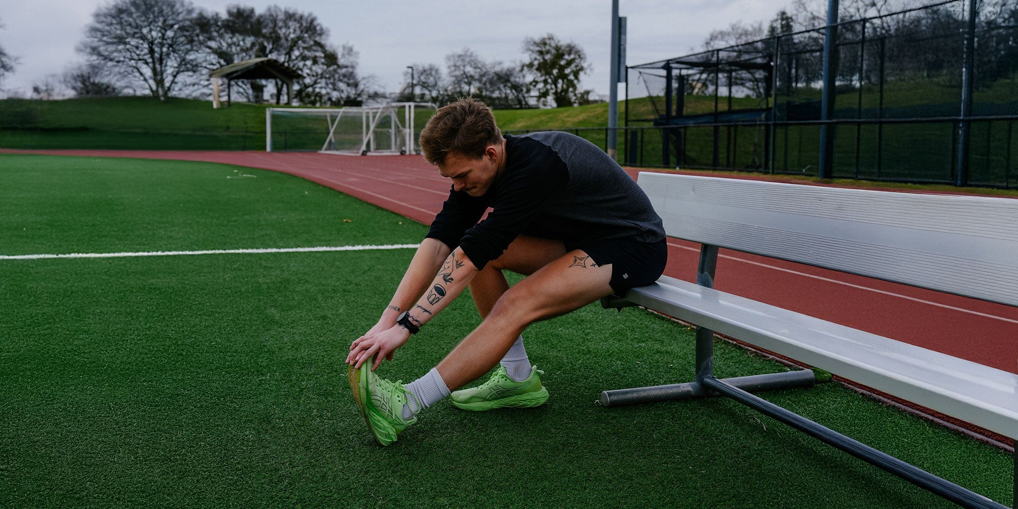 male athlete stretching on bench