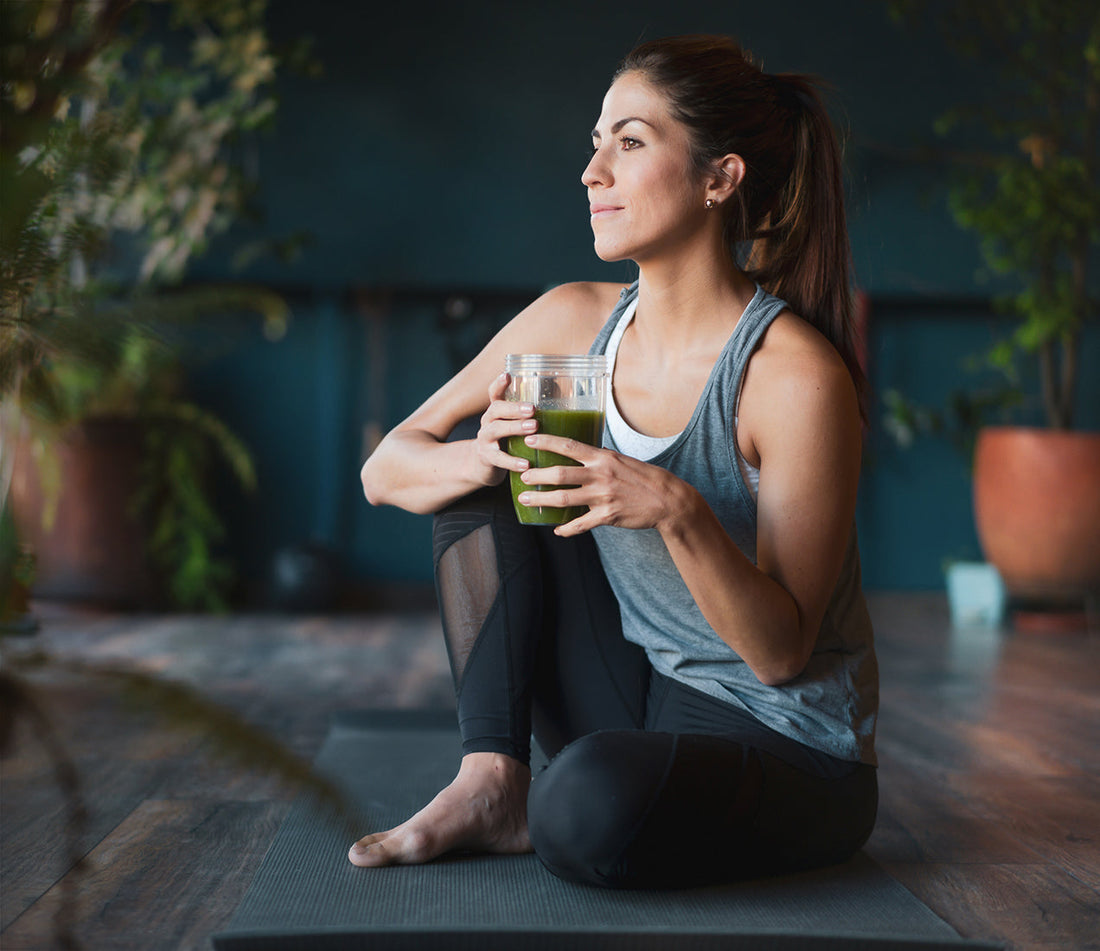 woman in yoga pose with green smoothie