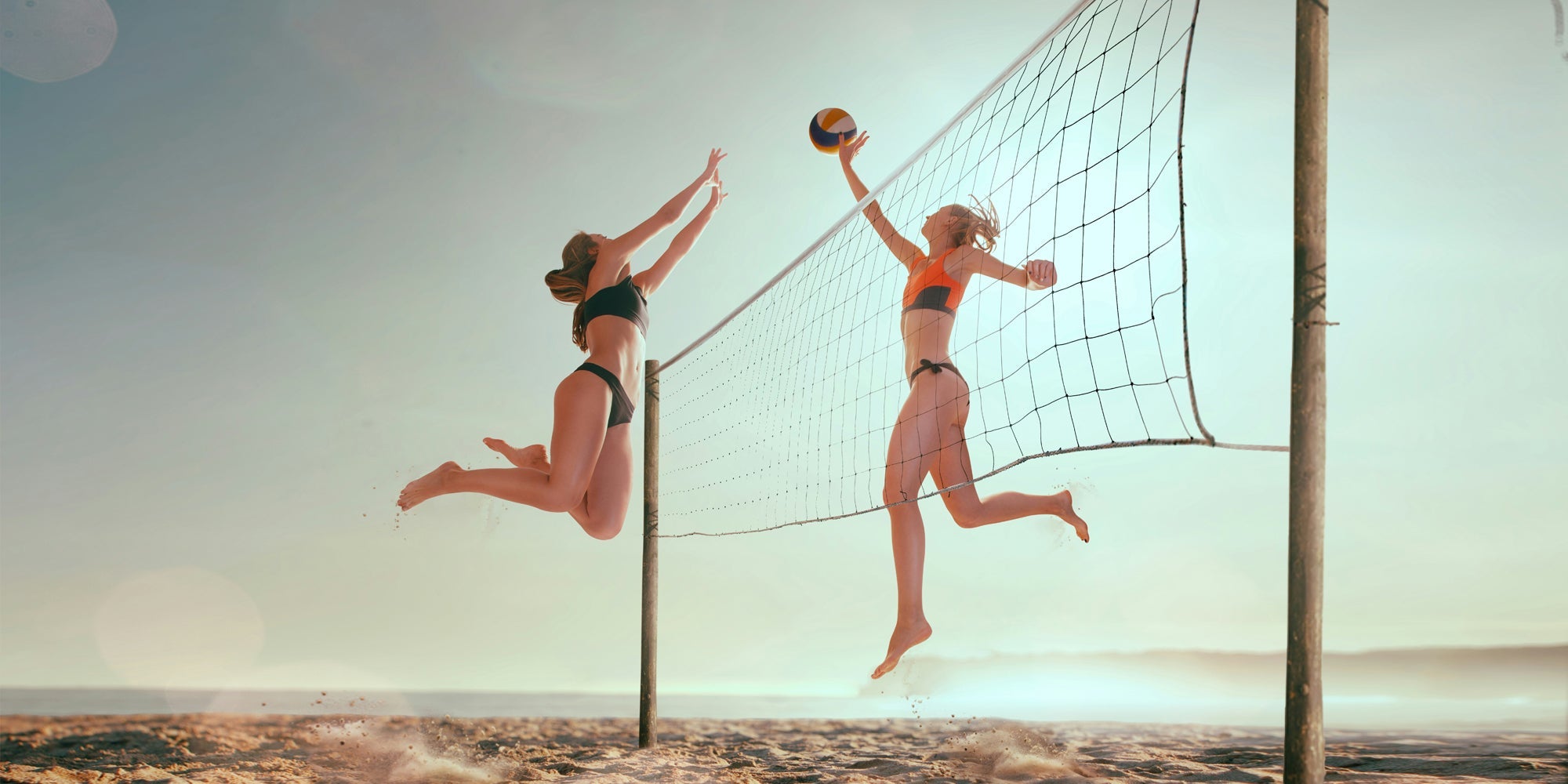 two athletes play beach volleyball