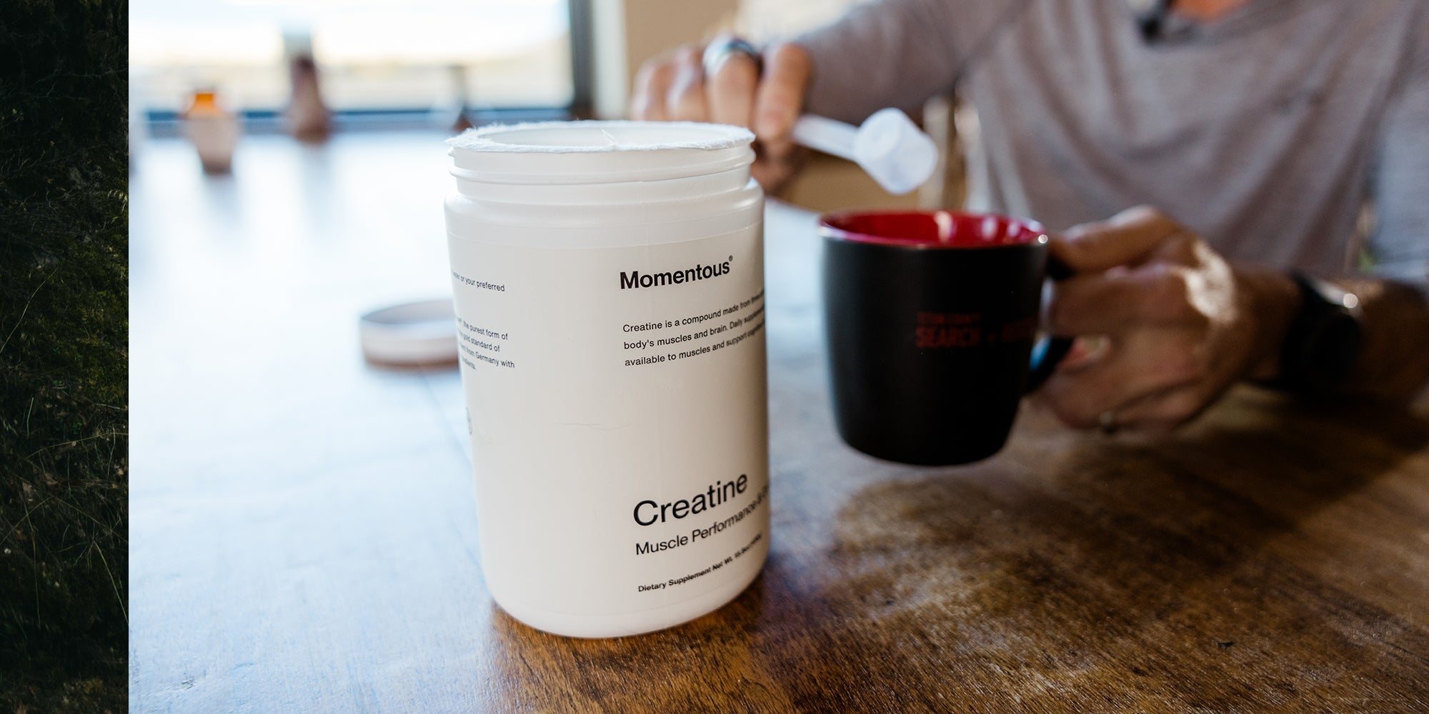 a tub of creatine with someone scooping it into a coffee cup