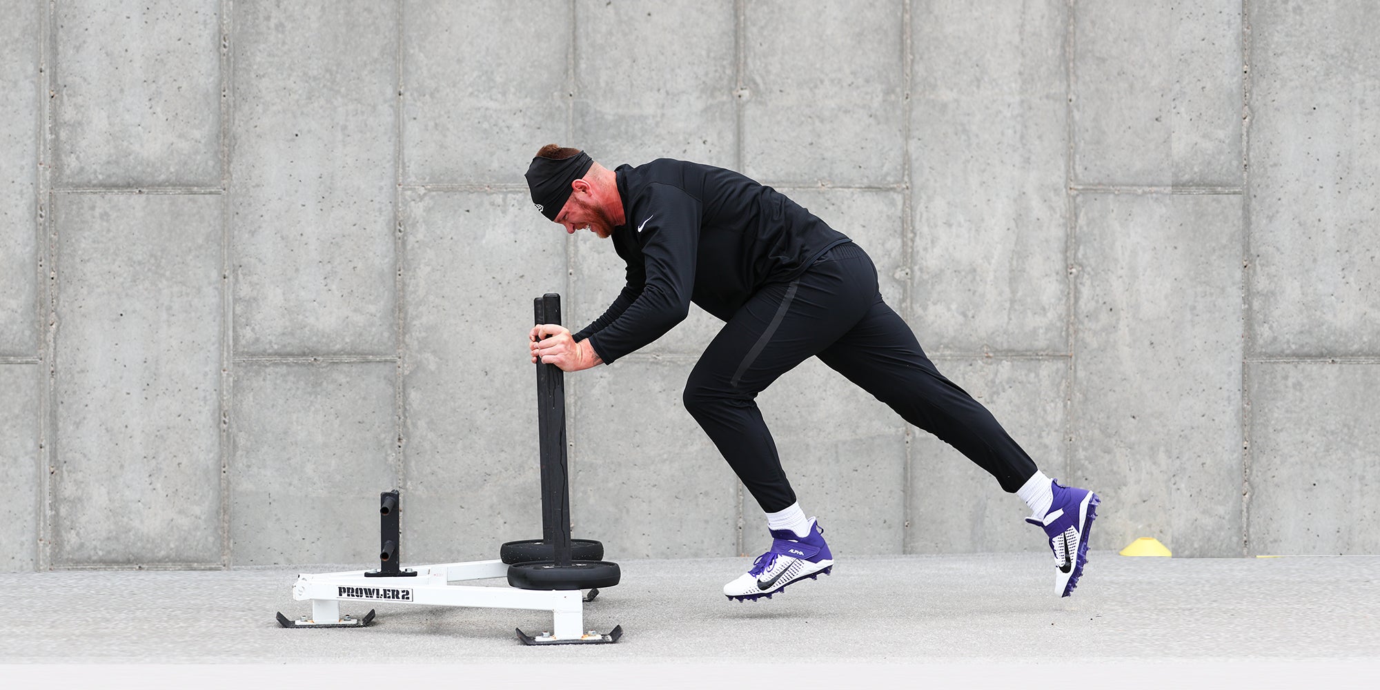 Athletic man running with sled