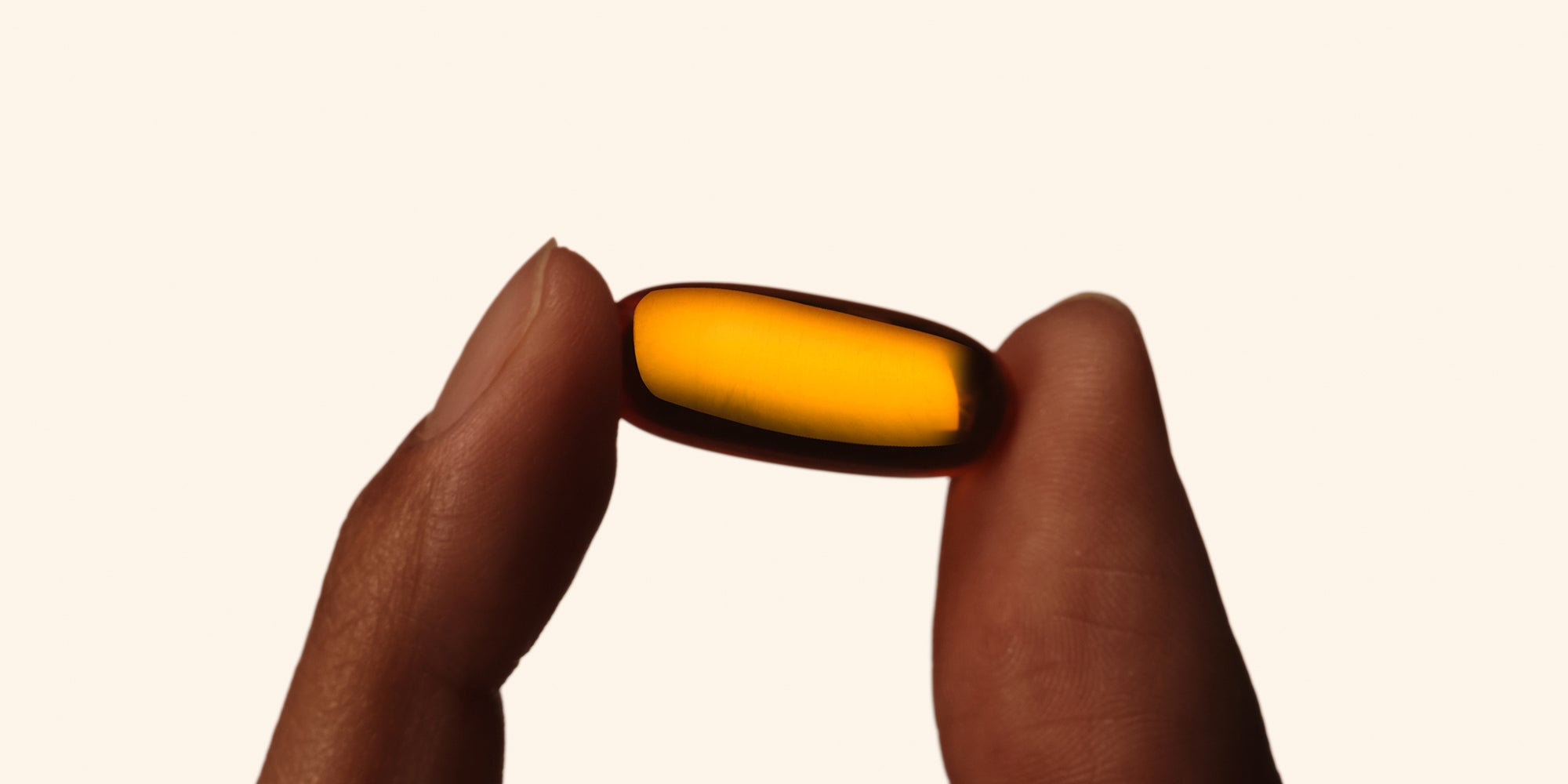 Momentous Omega-3 capsule between two fingers